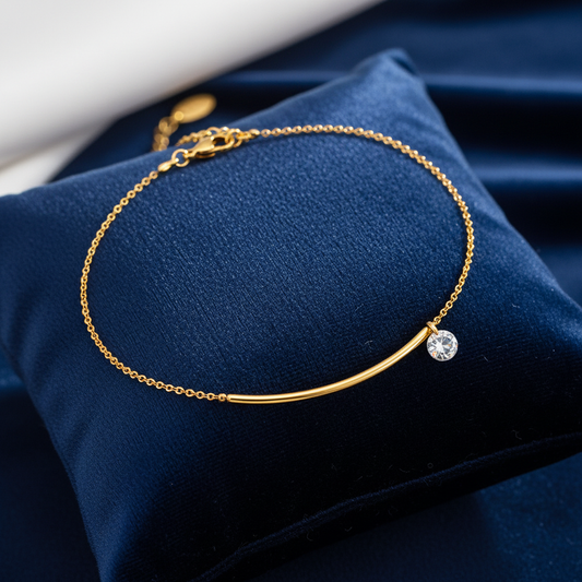Gold anklet on velvet cushion