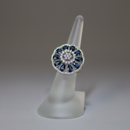 Blue sapphire and crystal flower ring on display stand