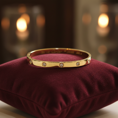 Gold bangle bracelet with crystal studs on velvet cushion