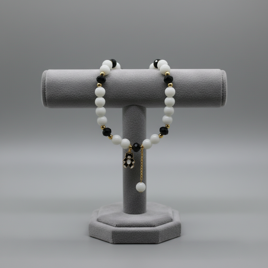 White and black beaded bracelet with panda charm on display stand