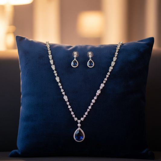 Blue sapphire pendant jewellery set on velvet cushion
