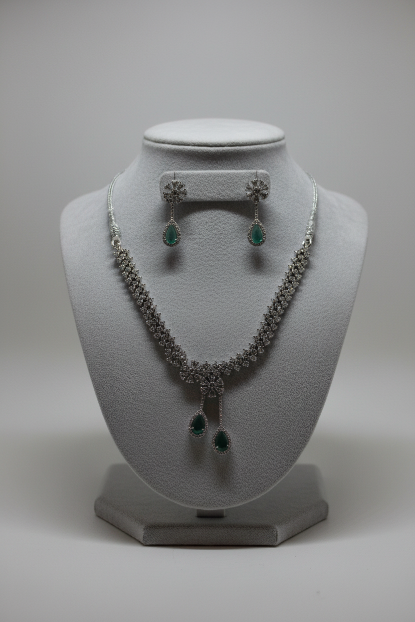 Emerald green necklace and earrings on jewellery stand