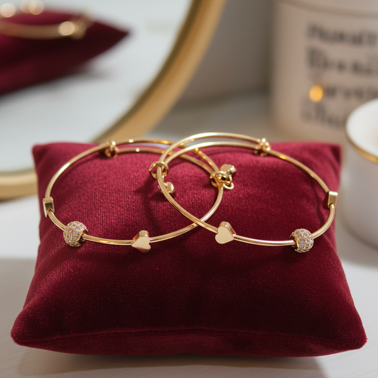 Set of 2 gold bracelets on cushion